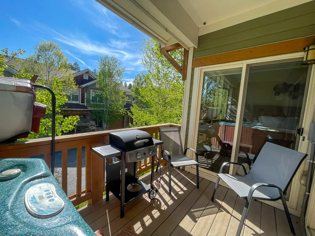 A relaxed outdoor space with a grill, outdoor chairs, and green trees, offering views of neighboring homes. The area is ideal for family barbecues, casual lounging, and evening gatherings under the stars.
